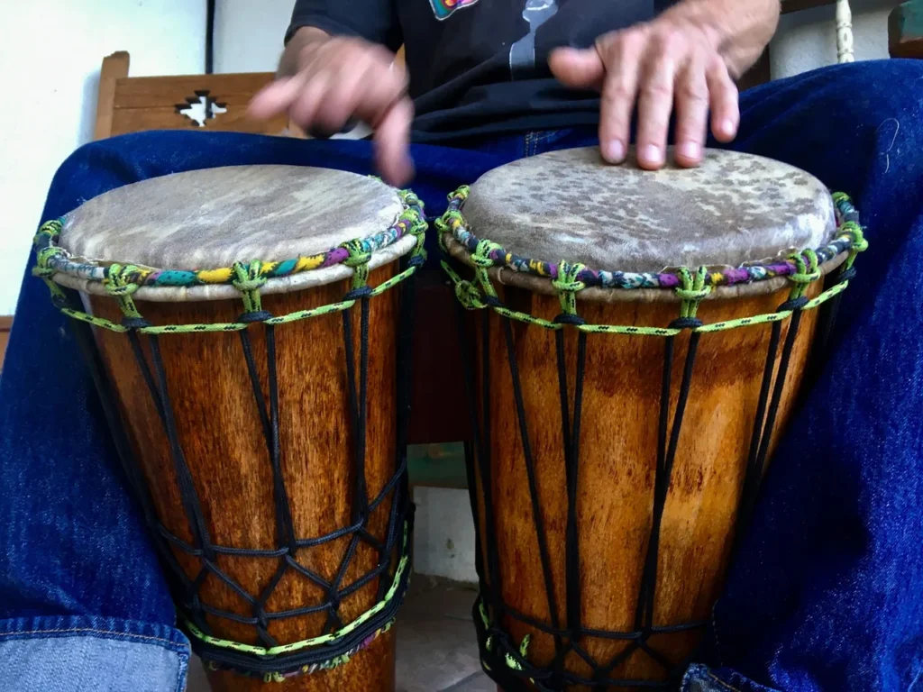 A man is playing an African harp called the Ilimba.