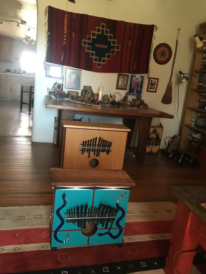 A living room with a wooden table, chairs, and a Kalimba.