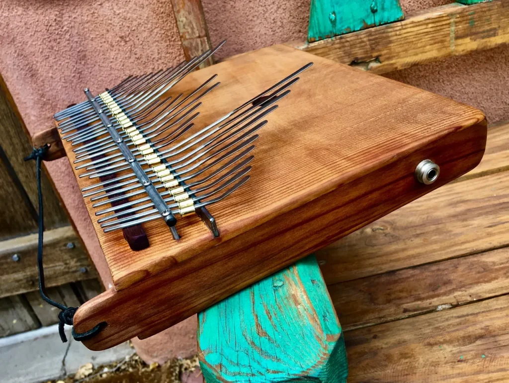 A Kongoma instrument is sitting on top of a wooden bench.