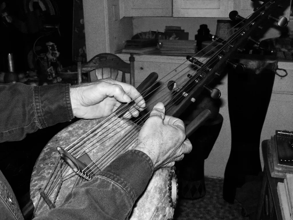 A man playing a Ngoma instrument in a kitchen.