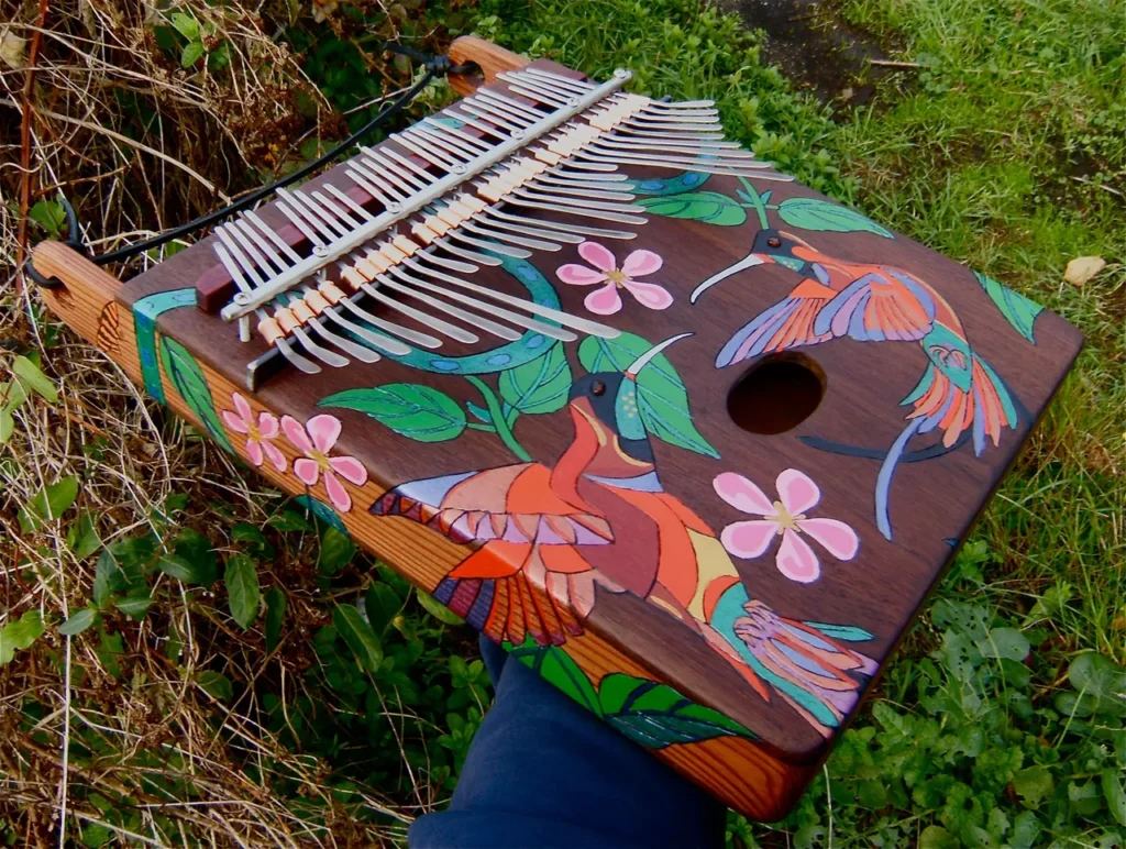 A person is holding a Ngoma, an African wooden hummingbird ukulele.