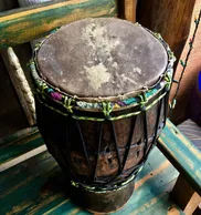 An African drum sitting on a wooden bench.