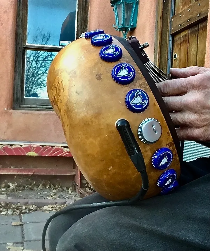 A man is playing an Ilimba, an African harp-like instrument with buttons on it.