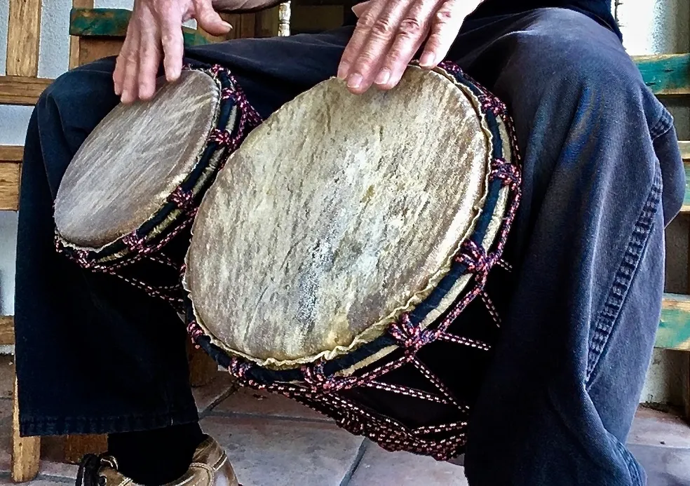 A man is playing an African harp called ilimba.