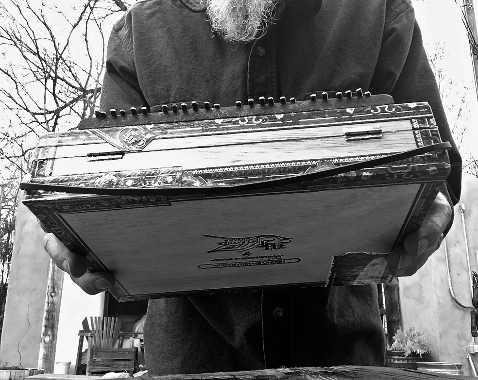 A Ngoma musician with a beard skillfully playing the accordion, creating mesmerizing African music.