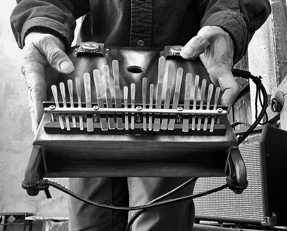 Black and white photo of a man holding a lamellaphone accordion.