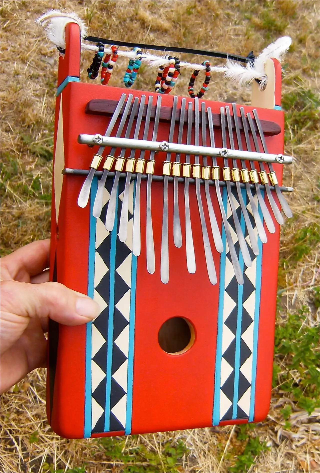 A person is holding a red Ngoma, an African musical instrument.